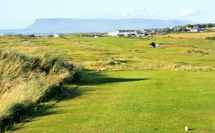 View of golf course green with cliffs