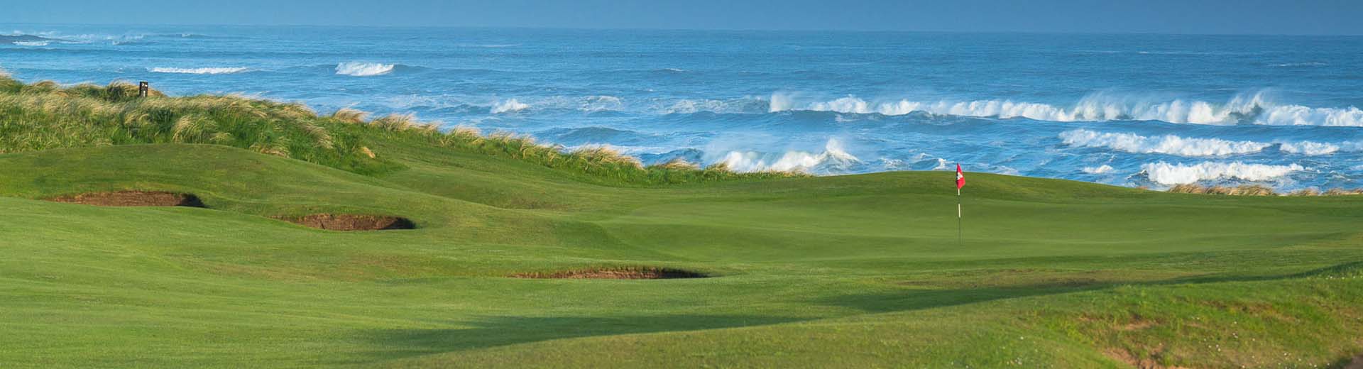 Golf course with flag and ocean coast